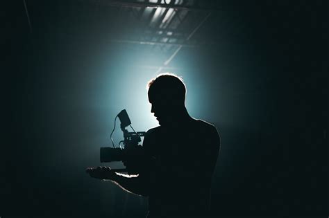 Silhouette Of Man Standing In Front Of Microphone · Free Stock Photo