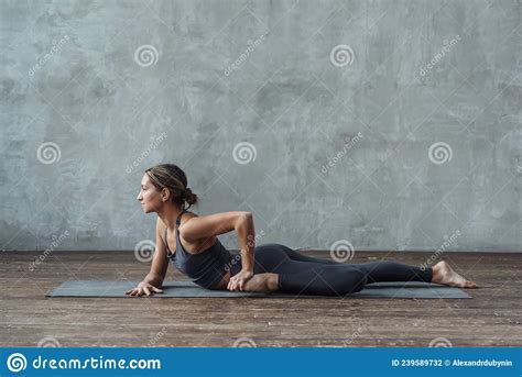 Slim Athletic Woman Practicing Yoga On The Floor Lying On Mat Doing