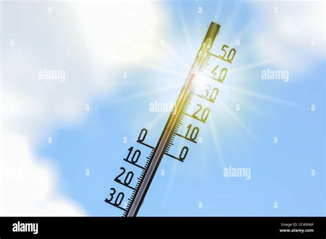 Thermometer Shows Heat In The Summer Season Against A Blue Sky With