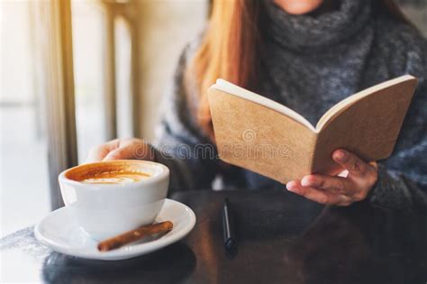 a beautiful woman reading a book while drinking coffee in the morning stock image image of
