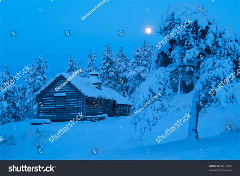 Cabin In The Snow Covered Forest At Night Stock Photo