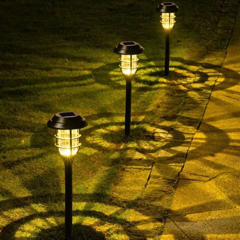 Three Solar Powered Lawn Lights In The Grass With Text Overlay That