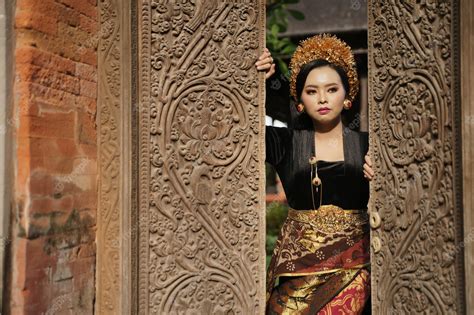 premium photo woman wearing balinese kebaya and woven cloth opening the door
