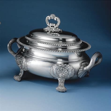 An Ornately Decorated Silver Pot And Cover On A Blue Background With