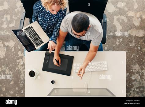 Top View Of Young Graphic Designers Working Together In Office Using