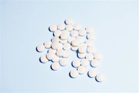 White Round Medication Pills On Sky Blue Surface · Free Stock Photo