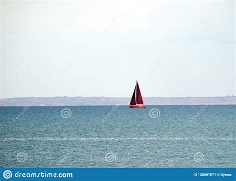 Landscape With Yacht With High Red Sails Floats Into The Sea In Calm