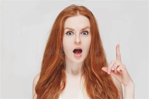 Beautiful Redhead Surprised Woman Picks Up The Finger On White Background Expressive Positive