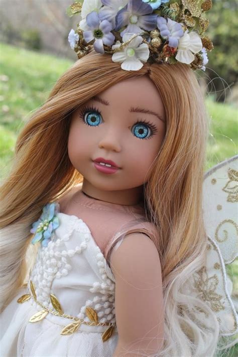 A Doll With Long Blonde Hair And Blue Eyes Wearing A Flowered Headpiece