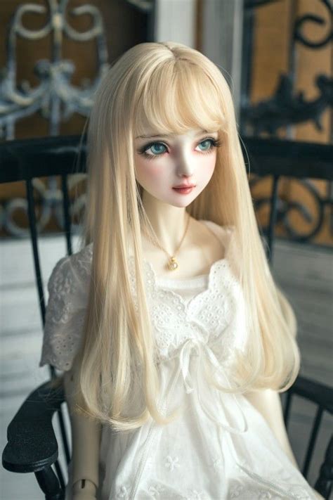 A Doll Sitting In A Chair With Long Blonde Hair And Blue Eyes Wearing