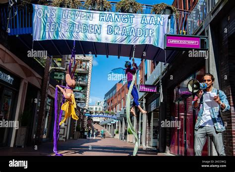 Two aerial acrobats are performing with aerial silk while an XR