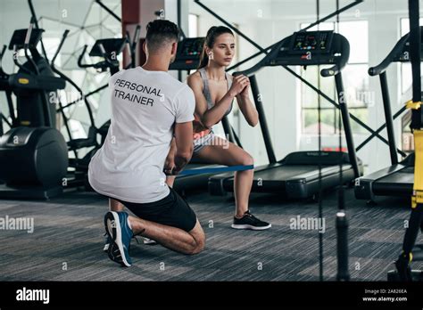 Back View Of Personal Trainer Controlling Attractive Sportswoman