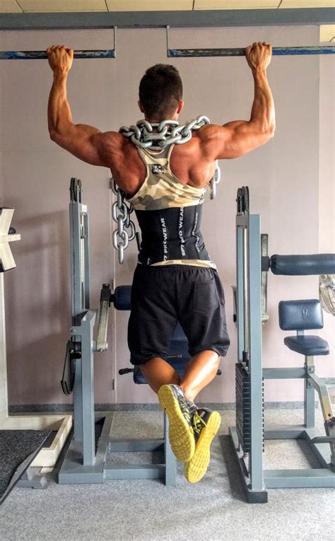 Muscular Man Doing Weighted Pull Ups Exercise