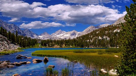 Beautiful Landscape Scenery River Grass Mountains And White Clouds