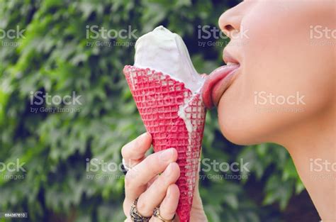 Hand Holding A Red Cone With Ice Cream Tongue Licking Ice Cream Close