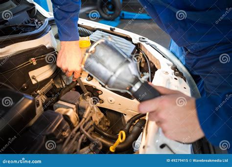 Mechanic Examining Under Hood Of Car With Torch Stock Image Image Of