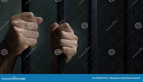 Hand Of Convicted Prisoner Behind The Cell Bar Inside Jail For