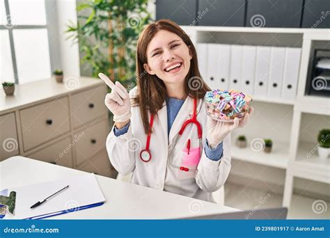 Young Doctor Woman Holding Sweets Candy Smiling Happy Pointing With