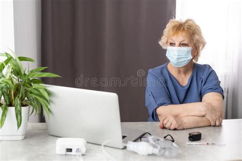 portrait of smiling senior woman wearing face mask near window old woman wearing surgical mask