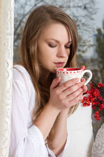 Girl Holding Cup And Looking Through Window Stock Photo Download