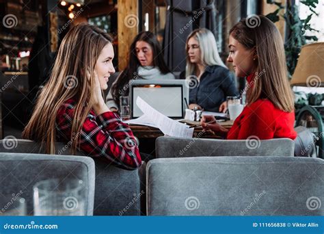 Two Young Businesswomen Discuss Work In A Cafe Stock Photo Image Of