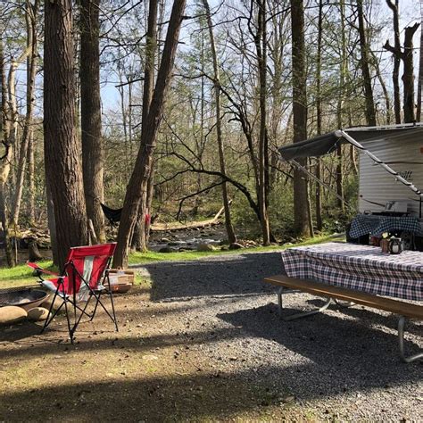 A Picnic Table And Chairs In Front Of A Camper