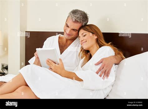 Happy Couple In Hotel Room Cuddle With A Tablet Computer Stock Photo Alamy
