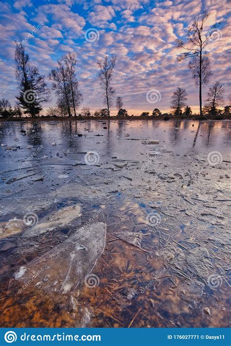 A Cold Sunset In Winter On A Frozen Lake With A Beautiful Sky And