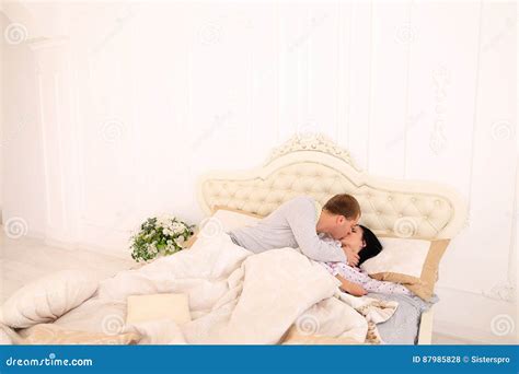 Husband Wakes Up Wife With Kiss Early In Morning White Roomr Stock