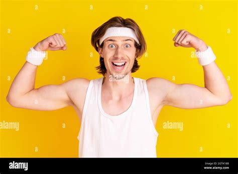 Portrait Of Attractive Cheerful Strong Guy Demonstrating Muscles