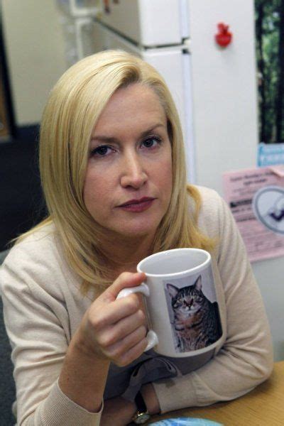 A Woman Sitting At A Table With A Coffee Mug In Front Of Her And A Cat