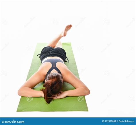 Woman Who Practices Yoga Relaxed Lying On The Mat Face Down On A White