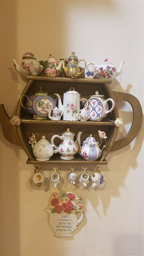 A Shelf With Teapots Cups And Saucers Hanging On It S Side