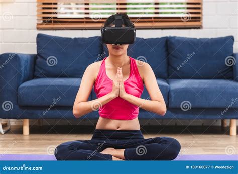 Asian Woman Use Virtural Reality Glasses Headset To Training Yoga Pose Online In Living Room