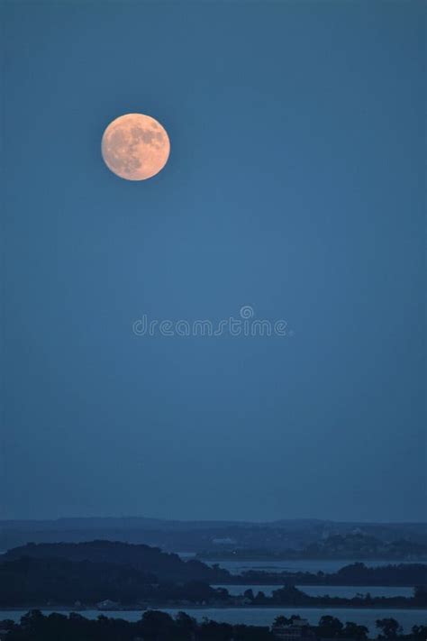 Imagen Vertical De Una Luna Llena En Un Cielo Azul Sobre Una Silueta