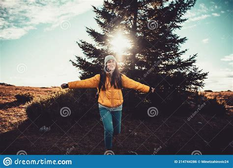 A Woman With Outstretched Arms Running Through Nature Stock Photo