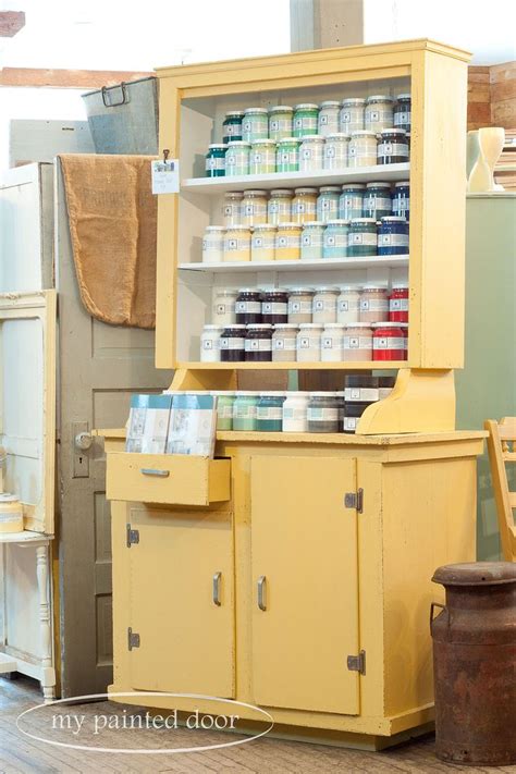 An Old Yellow Cabinet With Many Jars And Cans On Its Shelves In A Shop