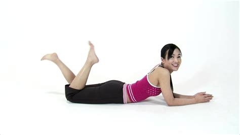 Woman Laying On Her Stomach Kicking Her Feet And Smiling On A White