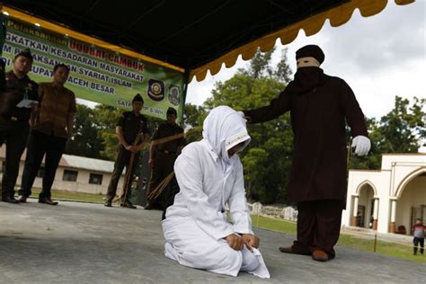 shocking moment indonesian woman is whipped by masked sharia law enforcer for committing