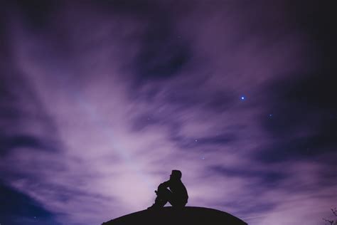 Silhouette Of Person Sitting Under Cloudy Sky During Nighttime Hd