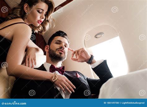 Sexy Woman Touching Chest Of Elegant Confident Man In Plane Stock Photography CartoonDealer