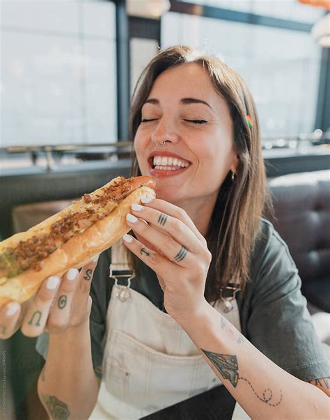 Young Woman Eating A Hotdog By Stocksy Contributor Susana Ramírez
