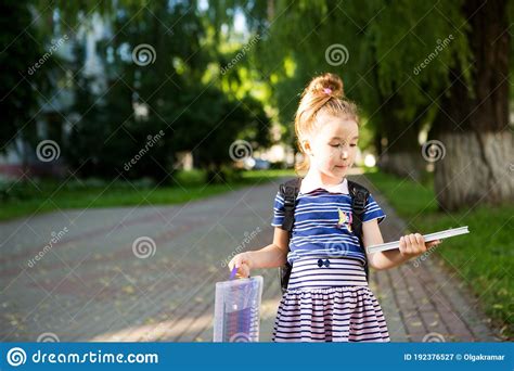 A Little Girl Of Caucasian Appearance In A School Uniform With A