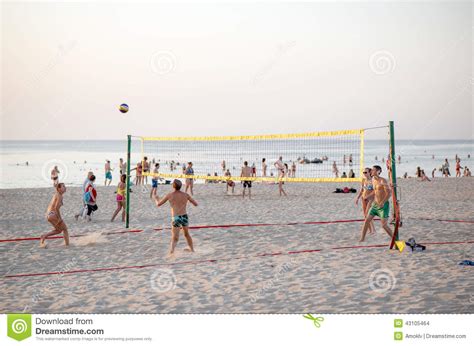 Группа в составе друзья играя волейбол на пляже Редакционное Стоковое Изображение изображение