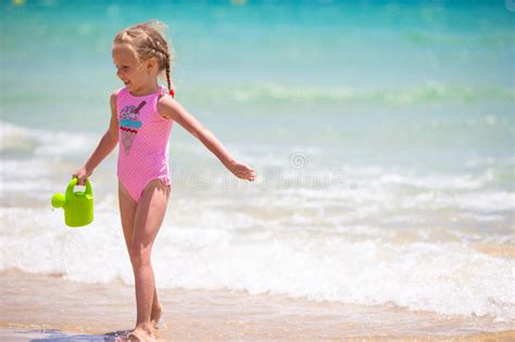 Прелестная счастливая маленькая девочка на белом пляже на заходе солнца Стоковое Фото