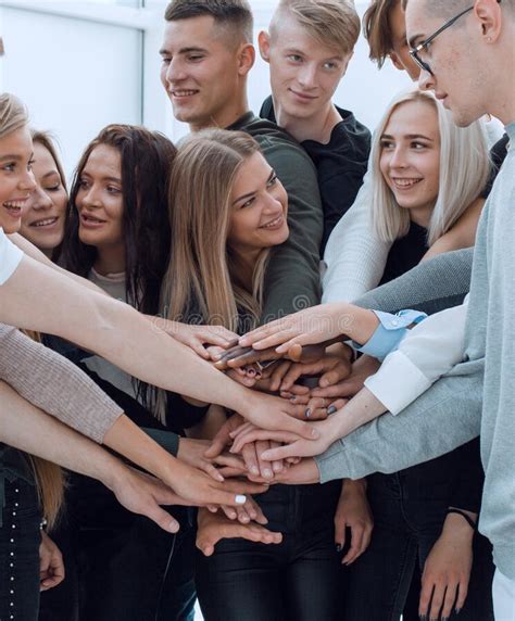 Large Group Of Young People Joining Their Hands Together Stock Photo