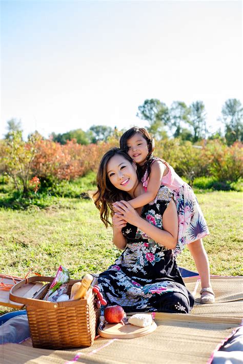 Happy Asian Mother And Daughter Having A Picnic In A Park By Stocksy