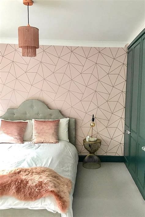 A Bedroom Decorated In Pink And White With Geometric Wallpaper
