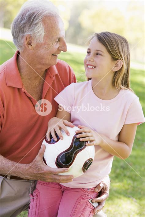 Grandfather And Granddaughter Outdoors With Ball Smiling Royalty Free