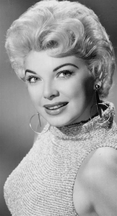 An Old Black And White Photo Of A Woman With Blonde Hair Wearing Large